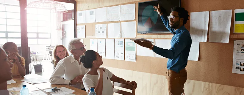 a digital marketer presenting to his team in a meeting room